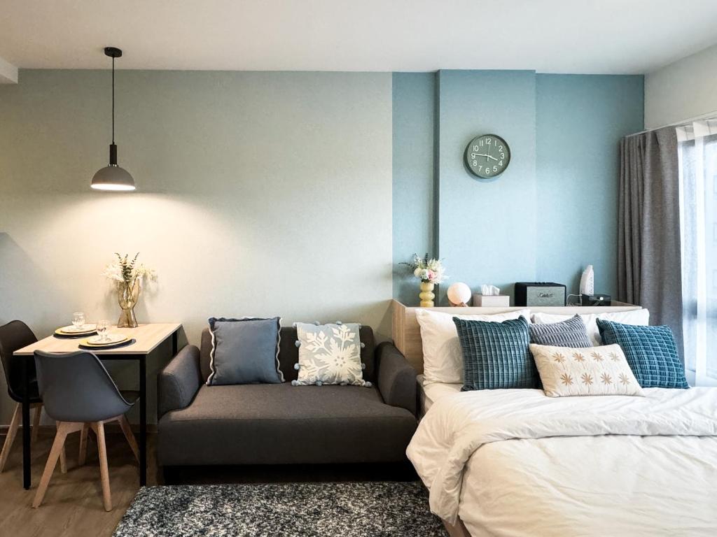 een woonkamer met een bed en een bank bij Vuela Casa 2 in Noord Pattaya