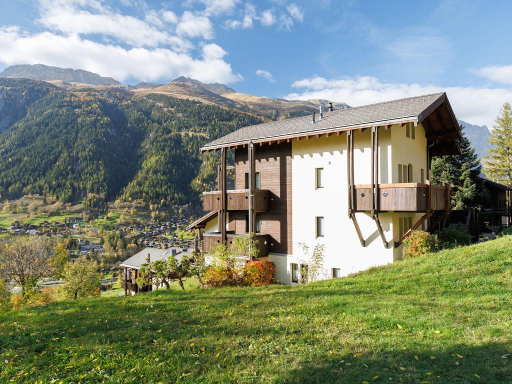 a house on a hill with mountains in the background at Apartment Aragon P36 by Interhome in Fiesch