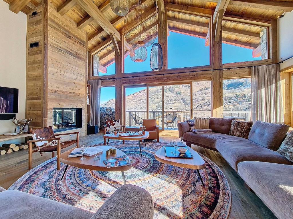 a living room with couches and tables in a room with mountains at Chalet La Panthère des Neiges in Saint-Martin-de-Belleville