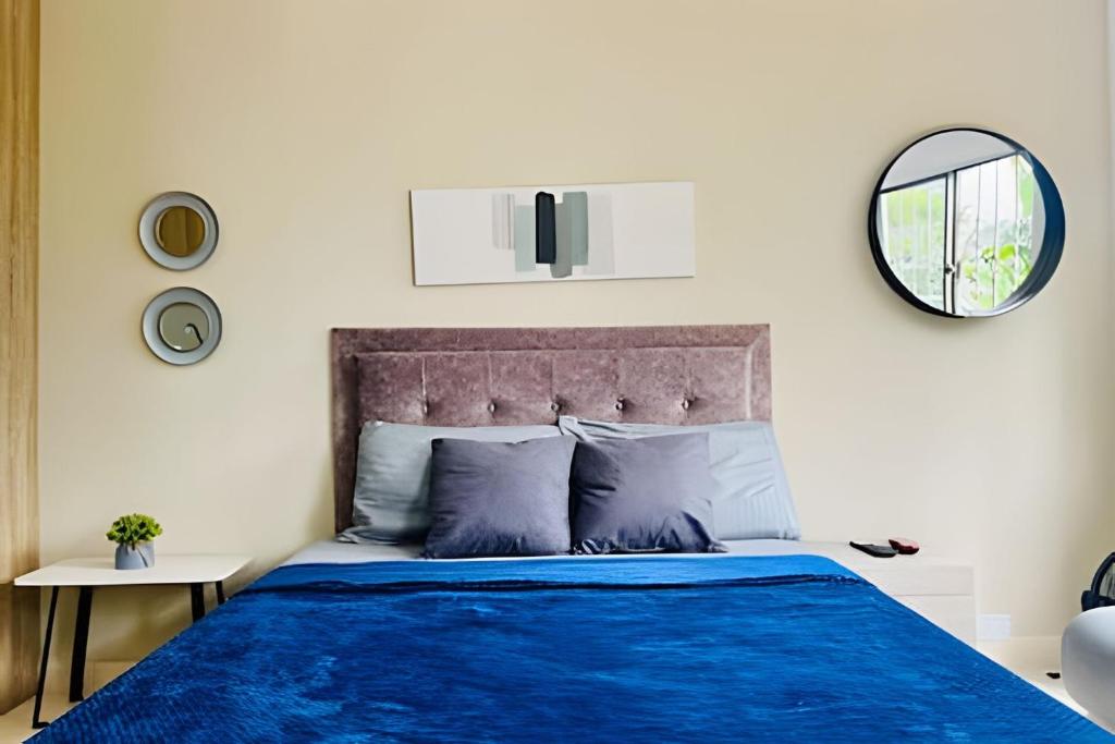 a bedroom with a blue bed and a mirror at 9804 · 9804 Loft Env. good view local experience confort in Envigado