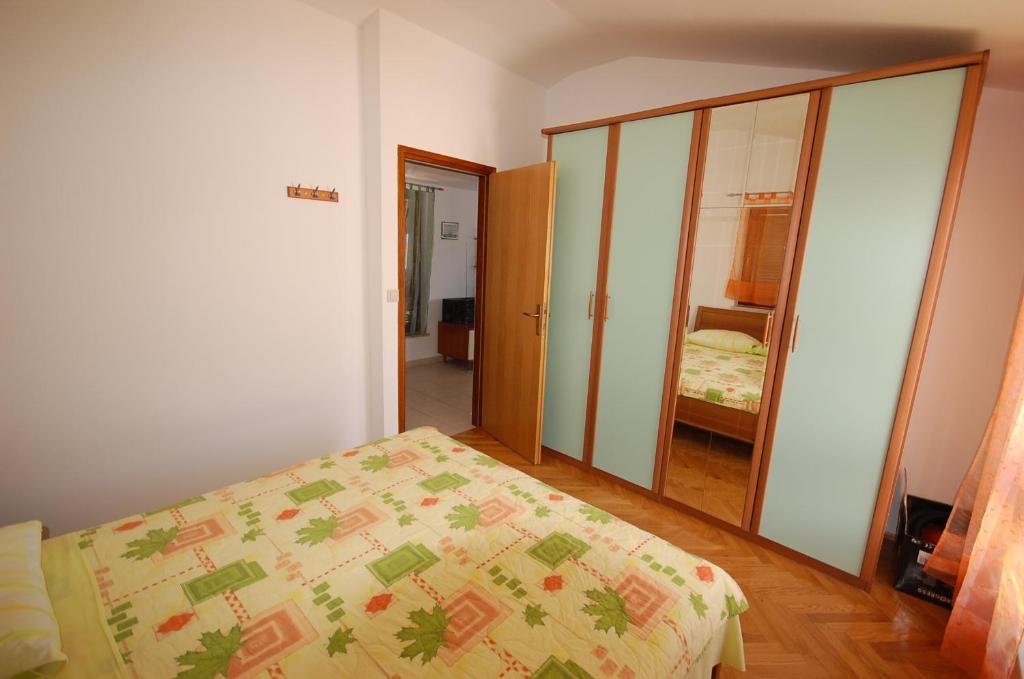 sypialnia z łóżkiem i lustrem w obiekcie Apartment Grozic w mieście Porat