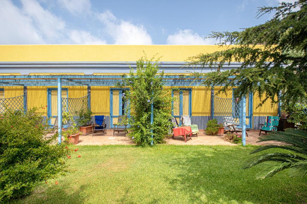 a yellow building with a yard in front of it at Solcalante in Procida