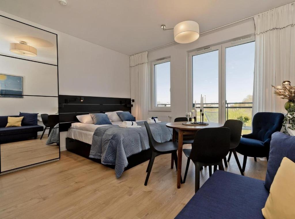 a bedroom with a bed and a table and chairs at Apartamenty Nexo Q4Apartments in Puck
