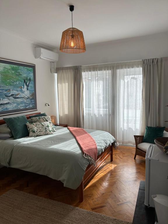 a bedroom with a large bed and a pendant light at MAR VERDE - Parede-Cascais in Parede