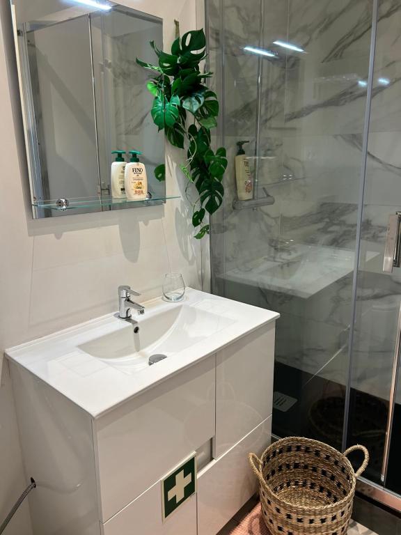 a bathroom with a white sink and a shower at MAR VERDE - Parede-Cascais in Parede