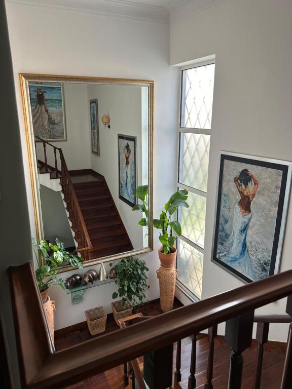 a hallway with a staircase with a mirror and plants at MAR VERDE - Parede-Cascais in Parede