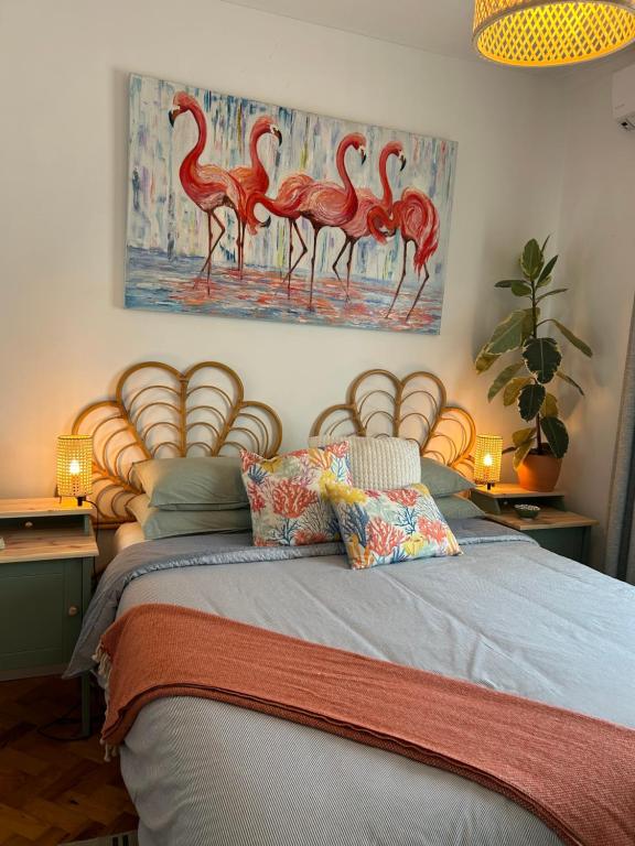 a bedroom with a bed with a painting of flamingos at MAR VERDE - Parede-Cascais in Parede