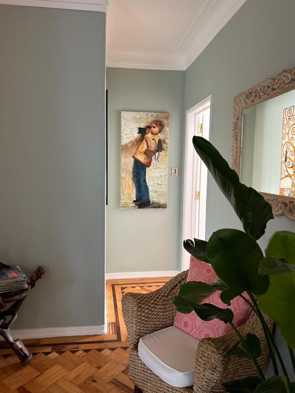 a living room with a chair and a painting on the wall at MAR VERDE - Parede-Cascais in Parede