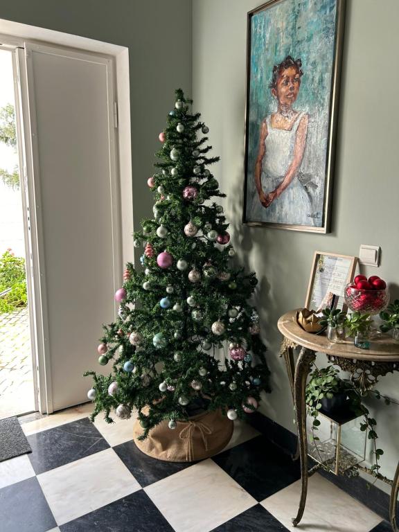 a christmas tree in a room next to a door at MAR VERDE - Parede-Cascais in Parede