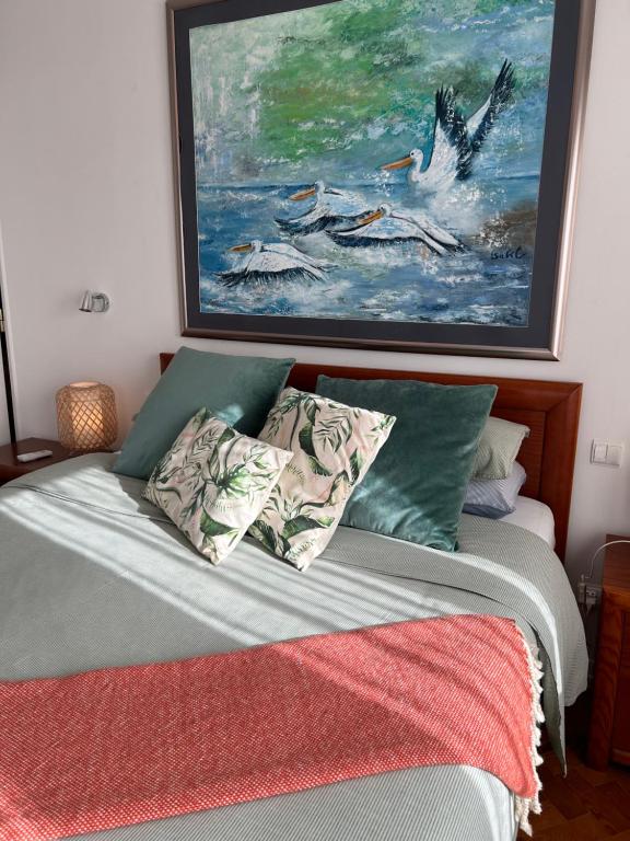 a bedroom with a bed with a painting on the wall at MAR VERDE - Parede-Cascais in Parede