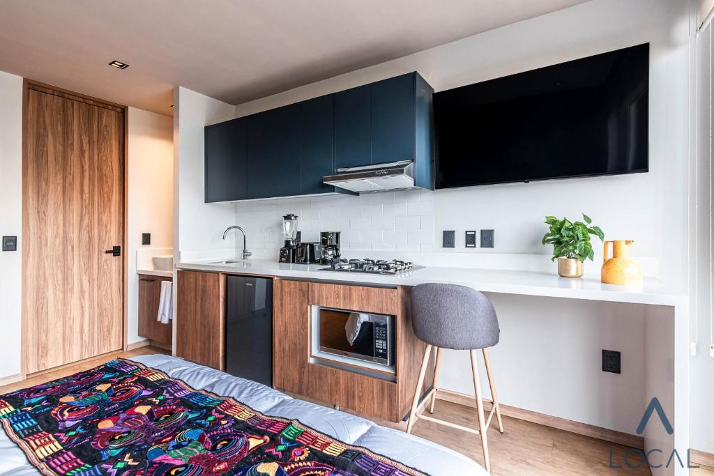 A compact kitchenette with cooking appliances and a breakfast counter.