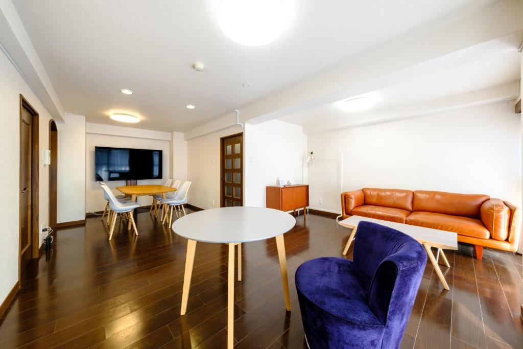a living room with a couch and a table and chairs at ベルビー川崎 in Kawasaki