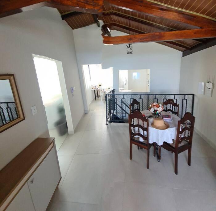Un comedor con una mesa y sillas en una habitación. en Cobertura frente mar 2 suítes, en Itapema