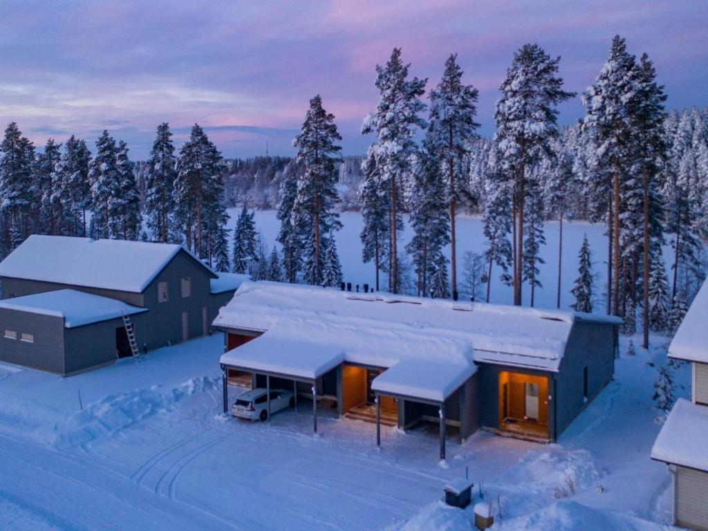 ein schneebedecktes Haus mit Bäumen im Hintergrund in der Unterkunft Holiday Home Vuokatin loiste 9 a 3 by Interhome in Vuokatti