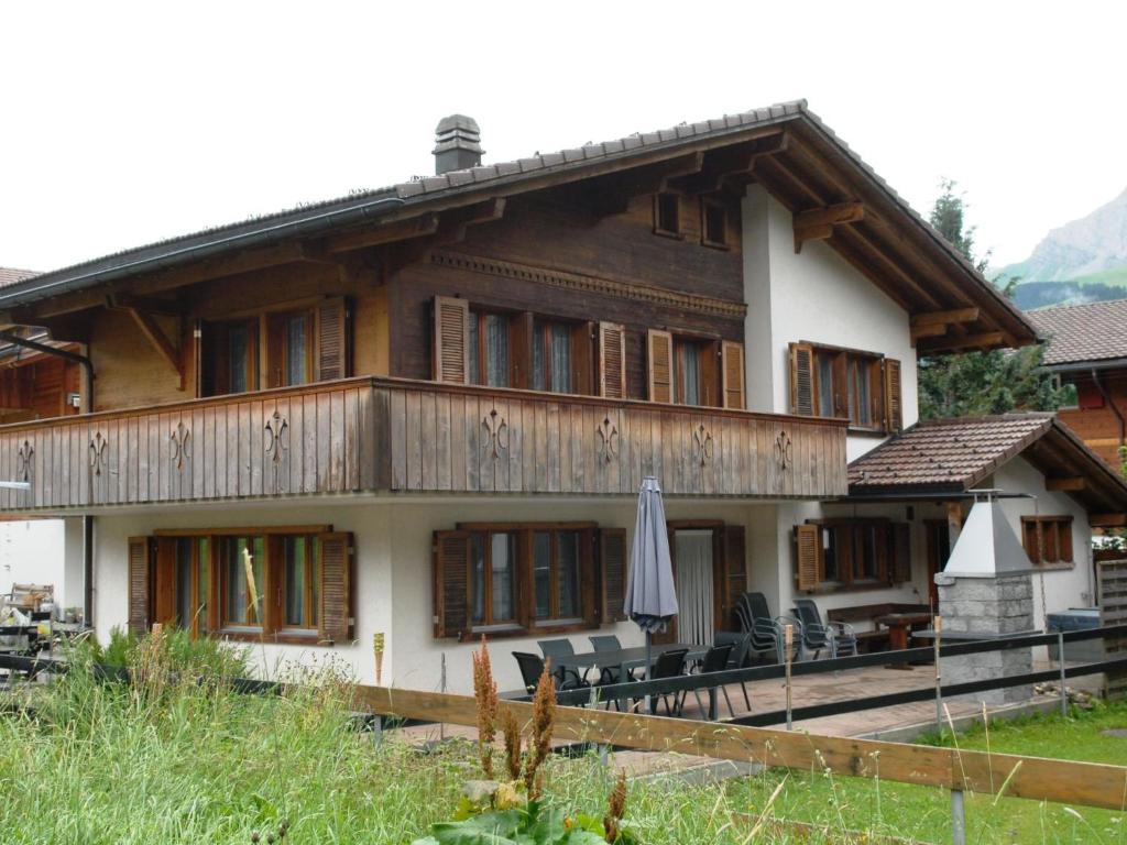 a house with a umbrella in front of it at Apartment Calanques by Interhome in Adelboden