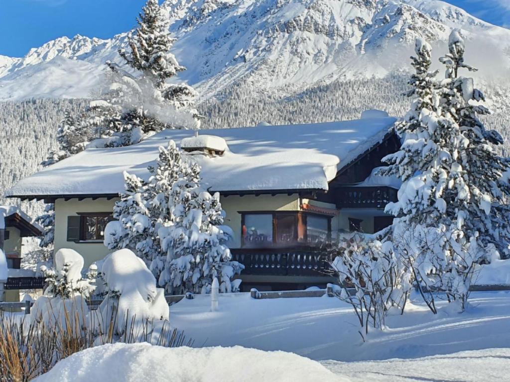 a house covered in snow in front of a mountain at Apartment Ferienwohnung Selina by Interhome in Lenzerheide