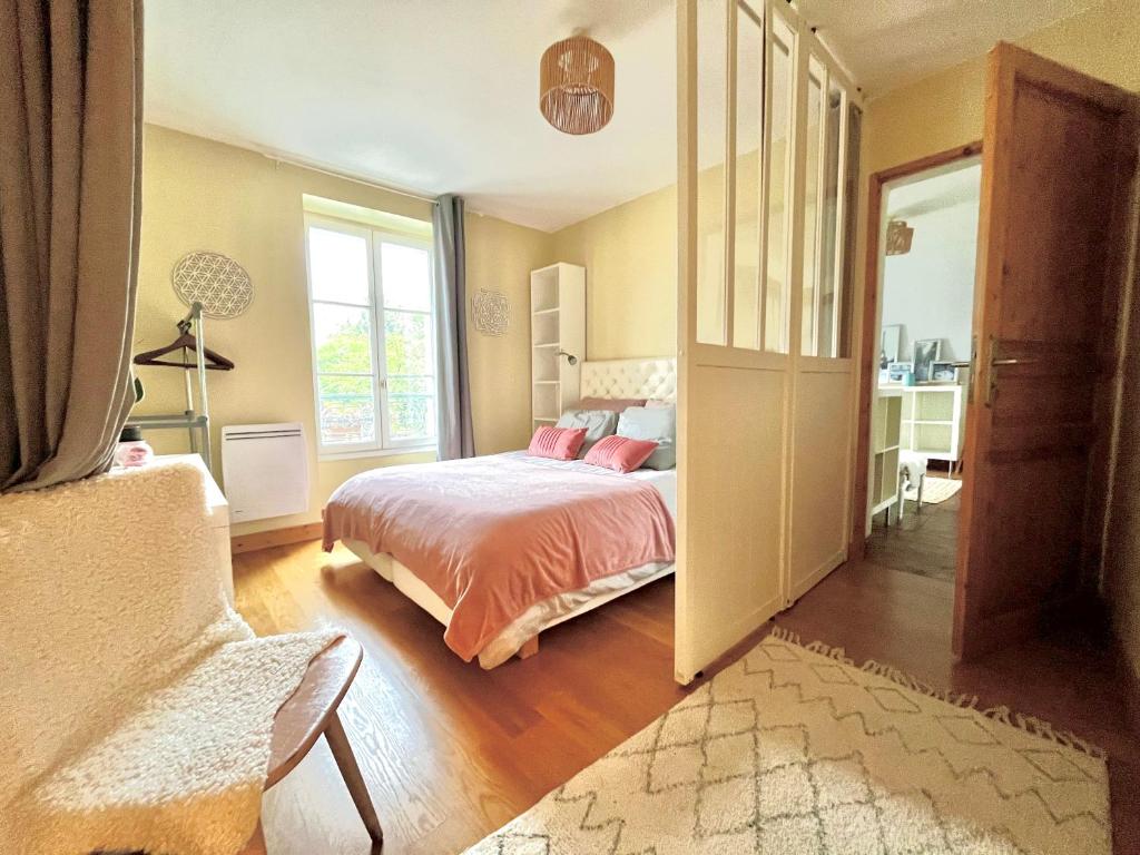 Un dormitorio con una cama y una ventana grande. en F3 confort proche Château-CDG-Paris, en Écouen