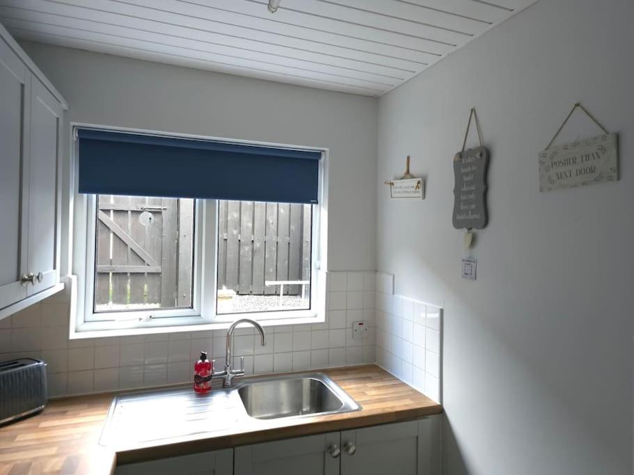 a kitchen with a sink and a window at Lights of Broadway Gaeltacht Quarter in Belfast