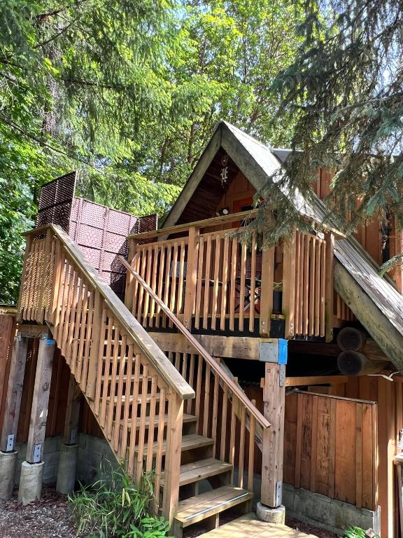 a tree house with stairs leading up to it at Five Elements Lodge B&B with Outdoor Spa in Fernwood
