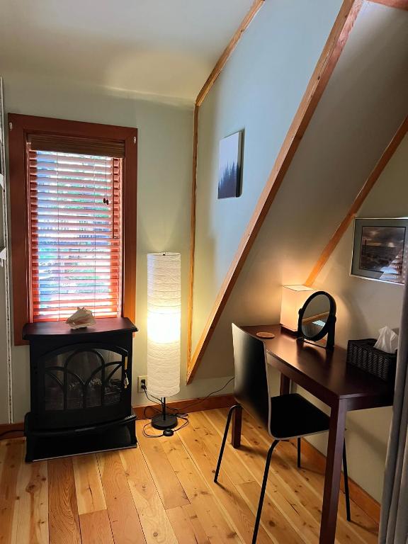 a living room with a desk and a staircase at Five Elements Lodge B&B with Outdoor Spa in Fernwood