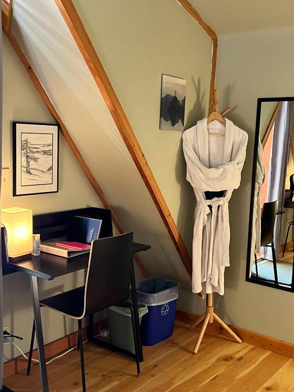 an attic room with a desk and a table with a mirror at Five Elements Lodge B&B with Outdoor Spa in Fernwood