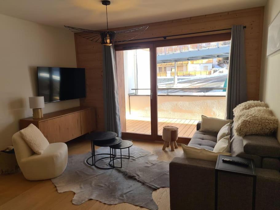 un salon avec un canapé et une grande fenêtre dans l'établissement Appartement 6 à 8 voyageurs, à Huez