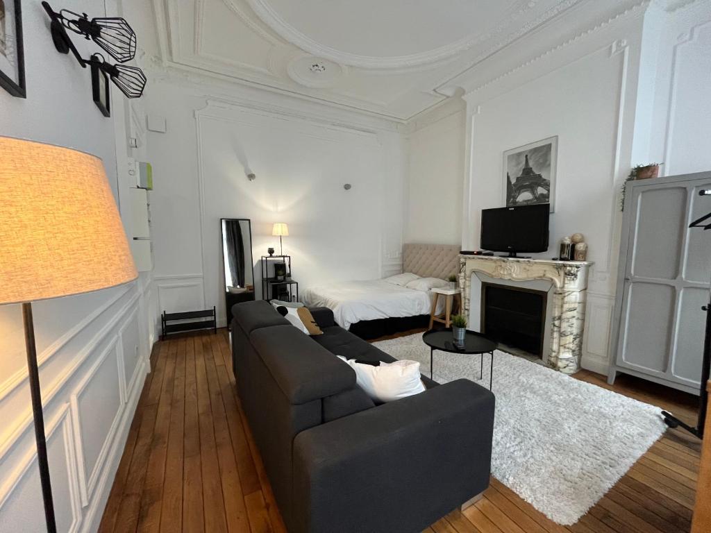 un salon avec un canapé et une cheminée dans l'établissement LA FAYETTE, à Reims