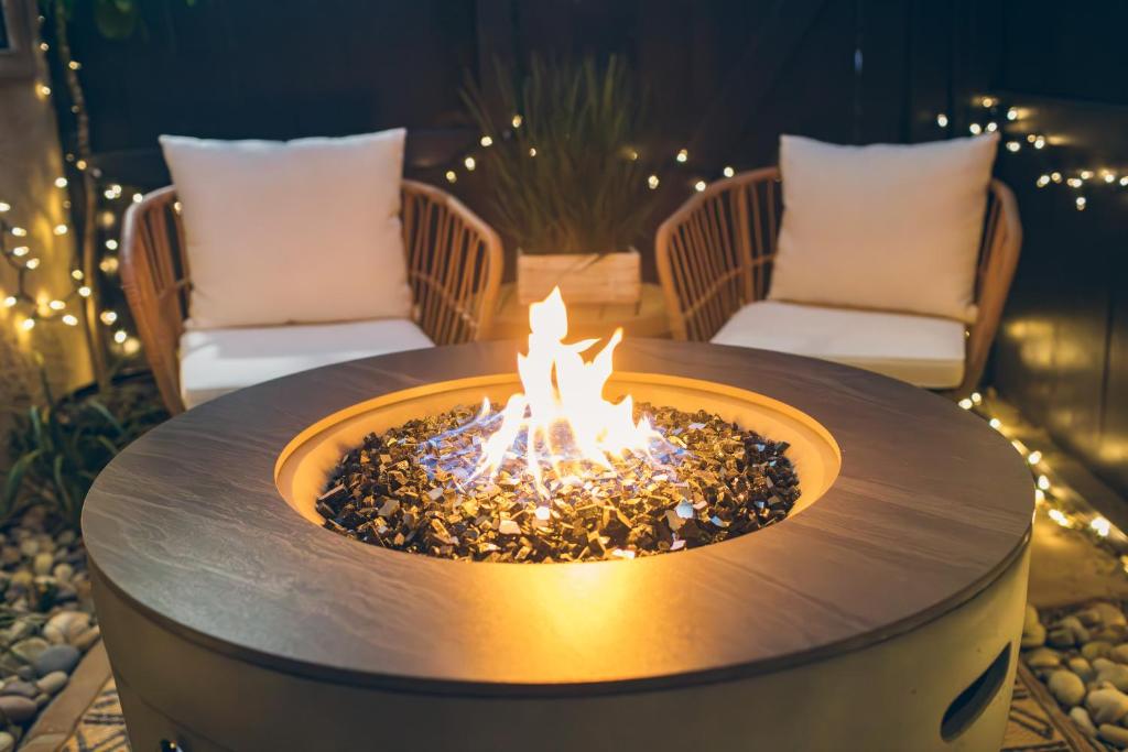 a fire pit in the middle of a patio with two chairs at Cali Condo+BBQ+MemoryFoamBeds+12min to Beach in San Juan Capistrano