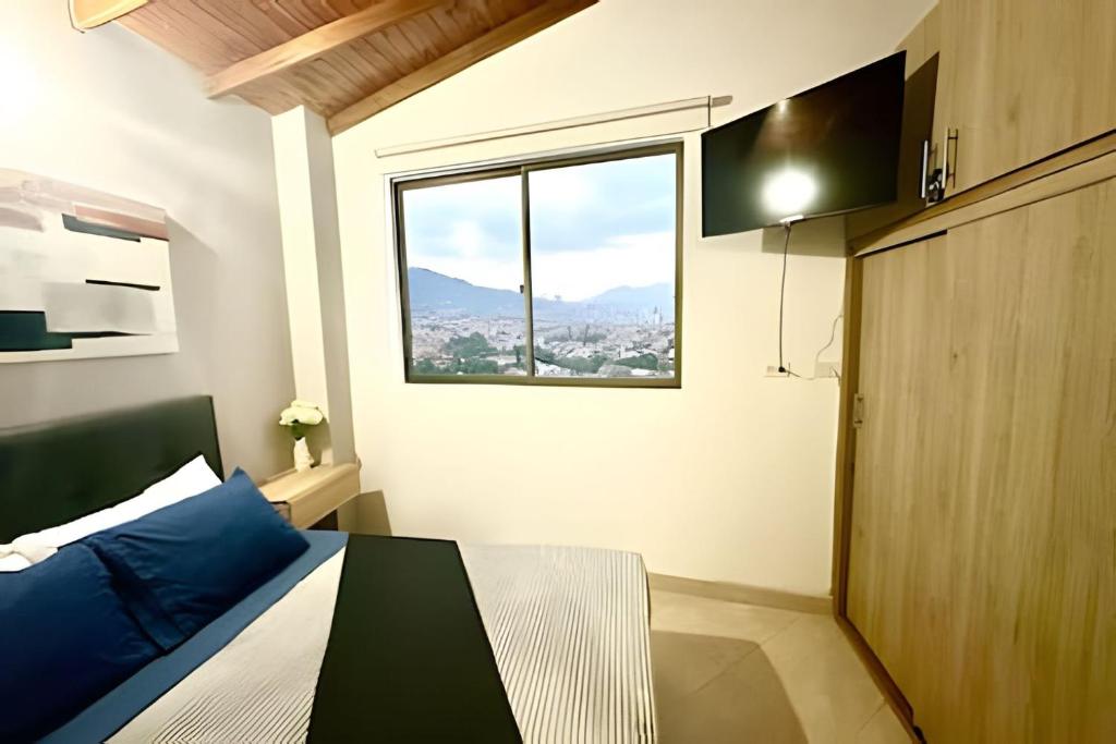 a small bedroom with a bed and a window at beautiful view of the city with local experience in Envigado