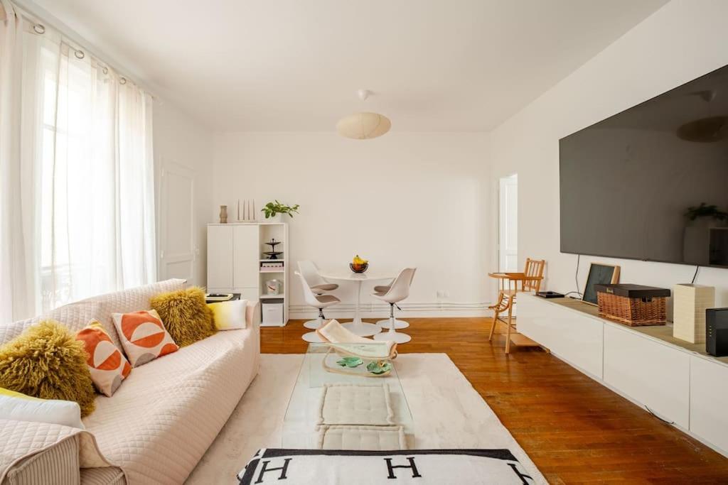 un salon avec un canapé et une télévision dans l'établissement Duplex spacieux, 10 min de Paris, à Puteaux