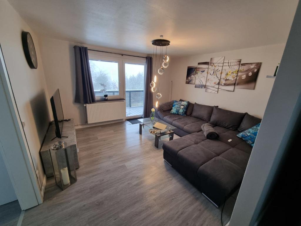 a living room with a brown couch and a window at Haus Ilse Wohnung 8 in Sankt Andreasberg