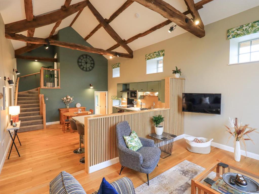 sala de estar con suelo y vigas de madera en Old Howgate Barn, en Ambleside