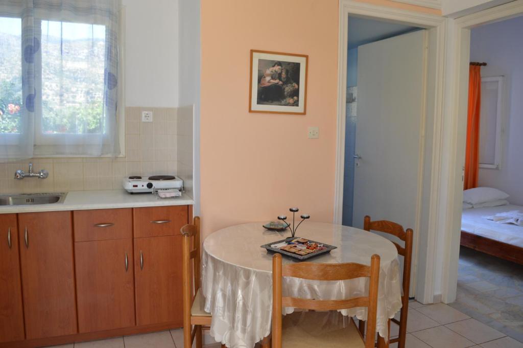 a kitchen with a table and a sink and a bed at Elli Studios & Apartments in Marathokampos
