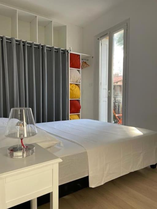 une chambre avec un grand lit blanc et une table dans l'établissement tres bel appartement au calme entre gare et centre, à Perpignan