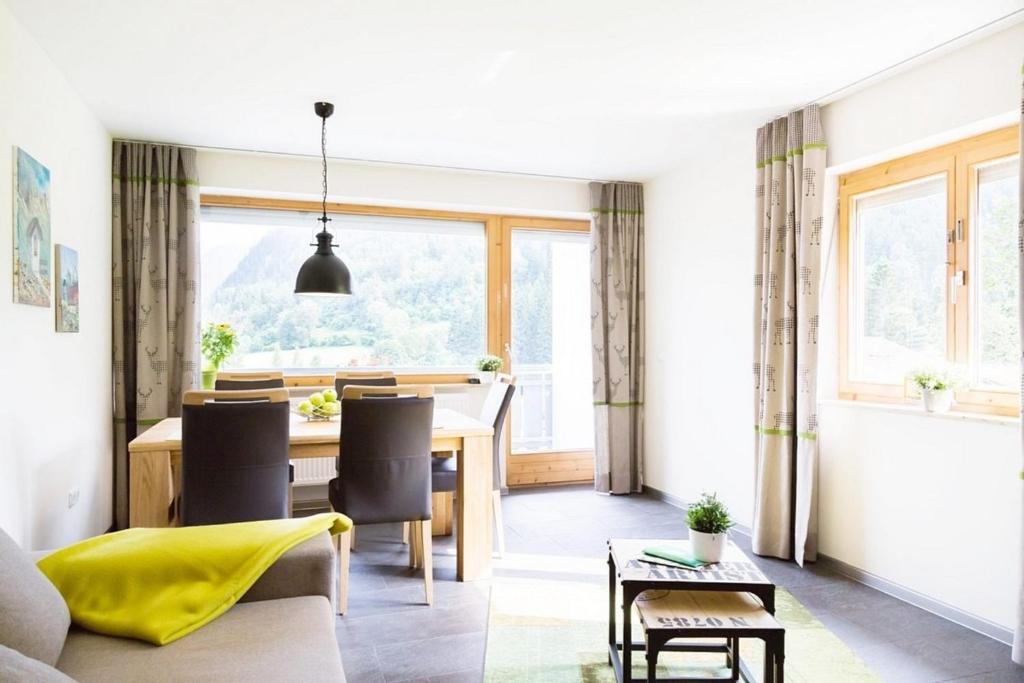 a dining room and living room with a table and chairs at Wildgrün Maxi Lodge 7 in Pfronten