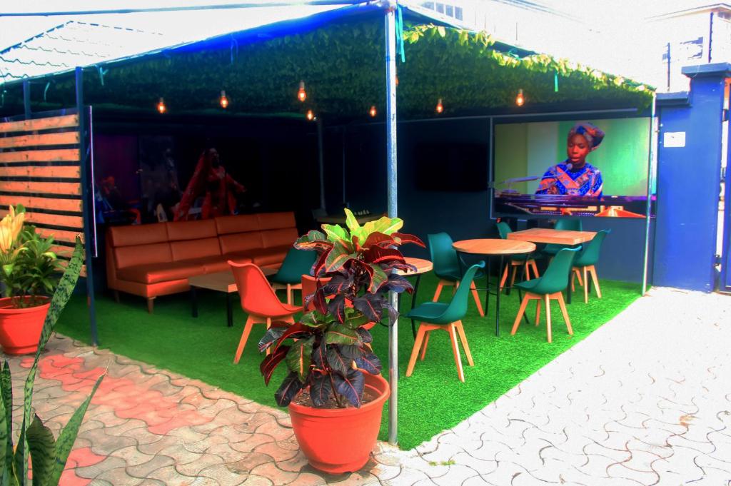 a patio with a table and chairs and a bar at Ringruby Hotel, Sangotedo in Sangotedo