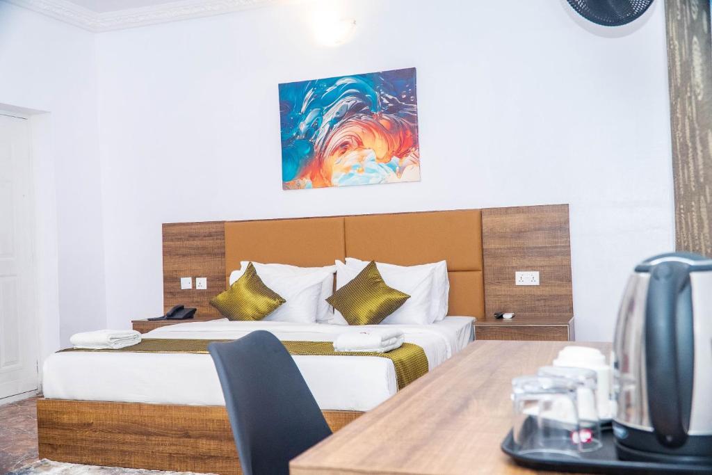 a hotel room with a bed and a table at Ringruby Hotel, Sangotedo in Sangotedo