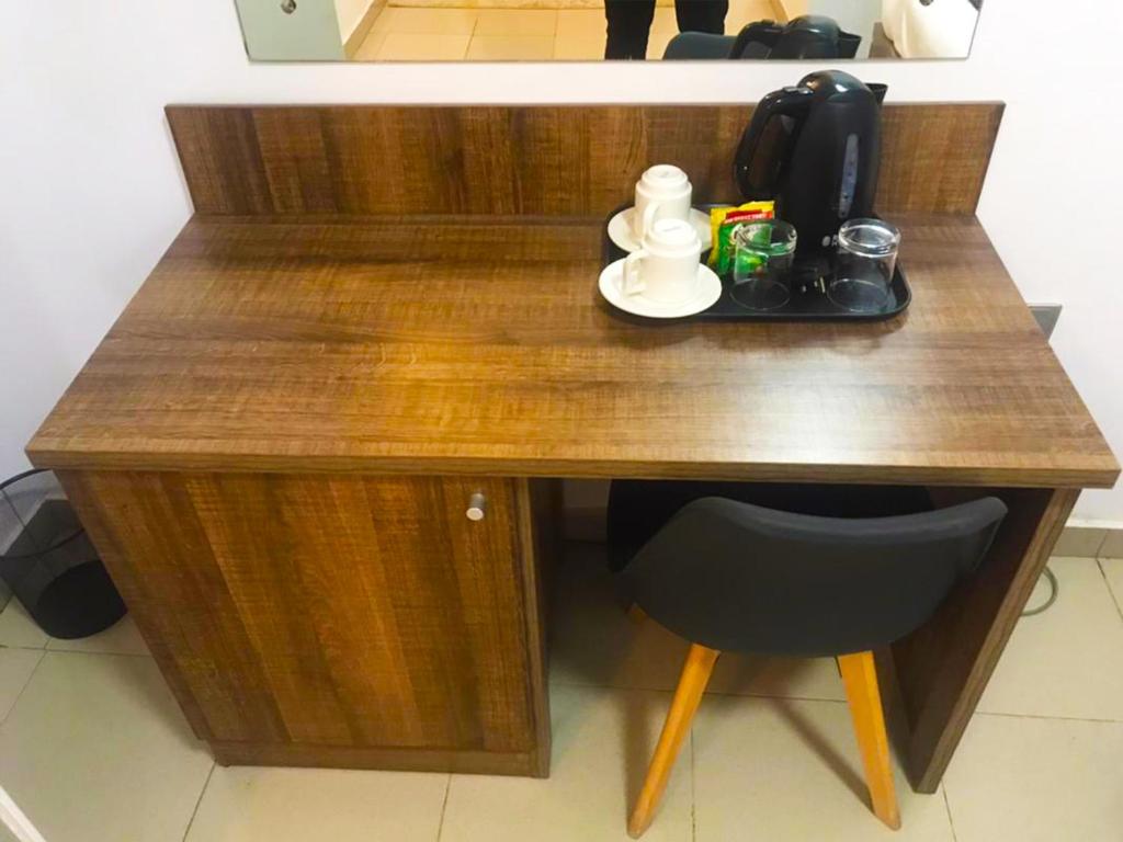 a wooden desk with a chair in a room at Ringruby Hotel, Sangotedo in Sangotedo