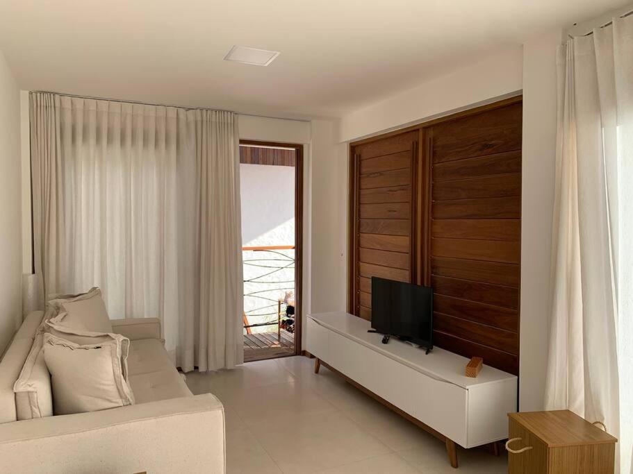 a living room with a couch and a flat screen tv at Villa Andorinha, Ap Vista para Montanha in Mucugê