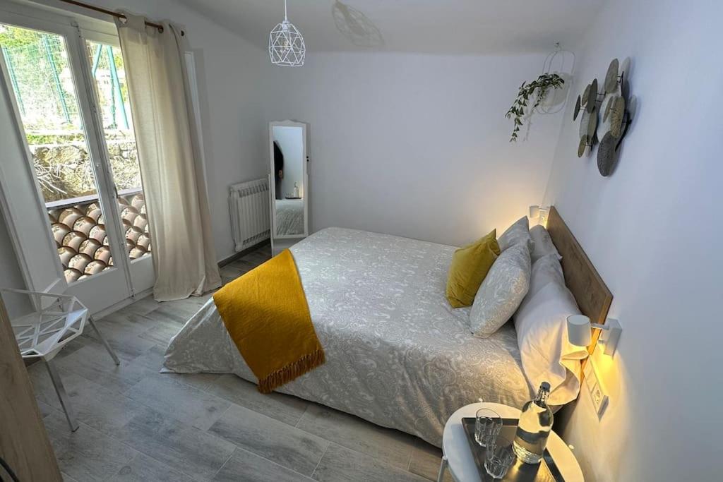a bedroom with a bed with a yellow blanket at Habitación Roca Foradada en Casa Camí de les Aigües Monistrol de Montserrat in Monistrol