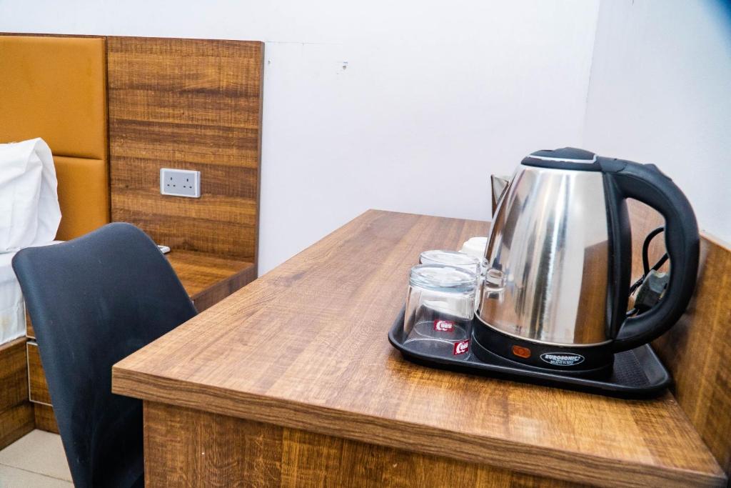 a tea kettle sitting on top of a wooden table at Ringruby Hotel, Sangotedo in Sangotedo