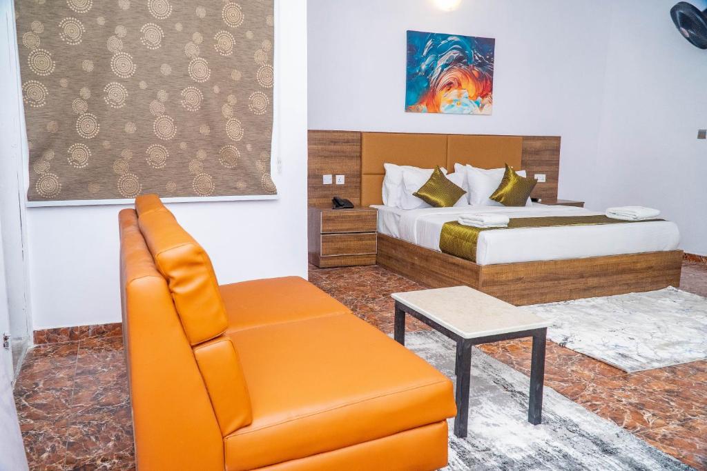 a hotel room with a bed and a chair at Ringruby Hotel, Sangotedo in Sangotedo