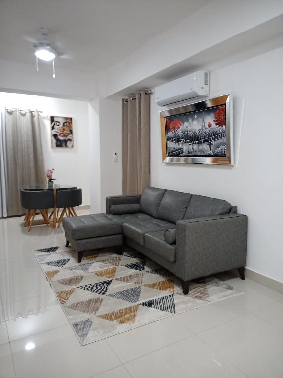a living room with a couch and a table at Modern Boca Chica Beach Apartment with Sea View in Boca Chica