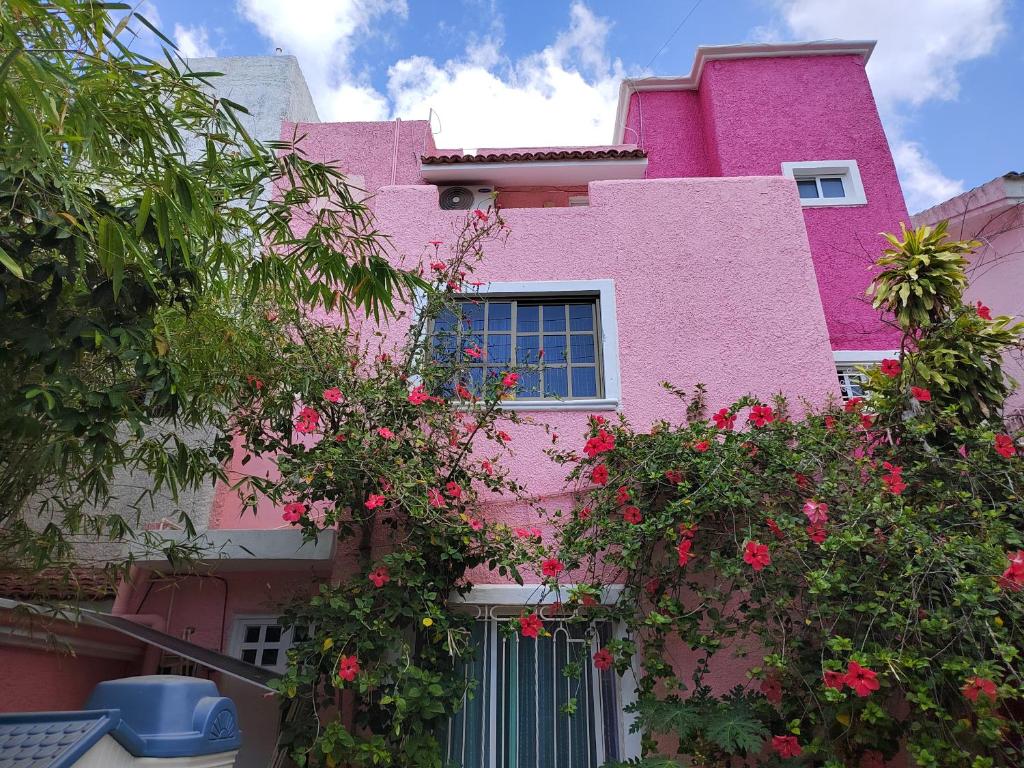 a pink building with flowers in front of it at Barbie home in Cancún