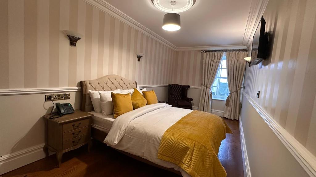 A bed or beds in a room at Sweeney's Hotel 2020 Limited