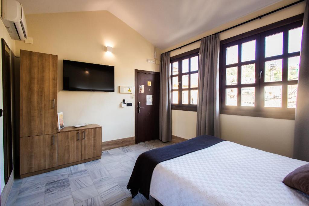 Posteľ alebo postele v izbe v ubytovaní Apartamentos Reyes Católicos