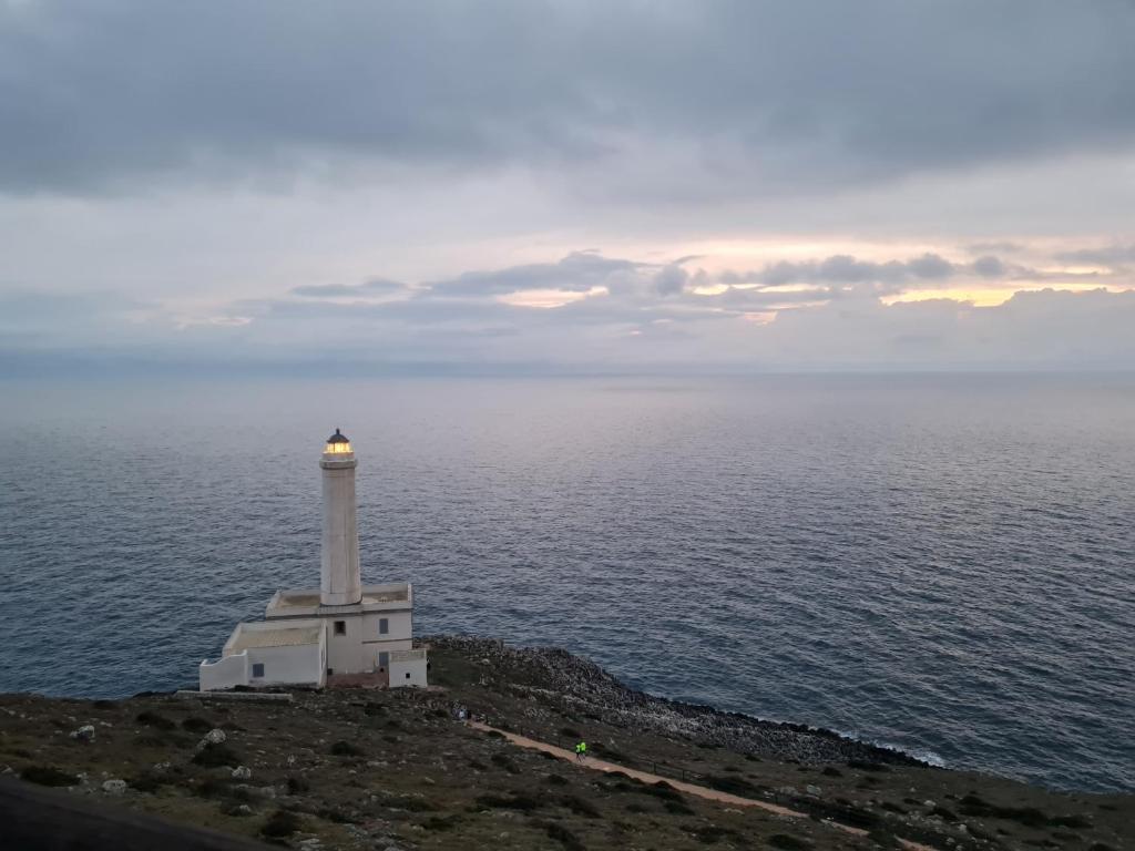 ein Leuchtturm auf einem Hügel in der Nähe des Ozeans in der Unterkunft Appartamento tra sole, mare e natura in Otranto