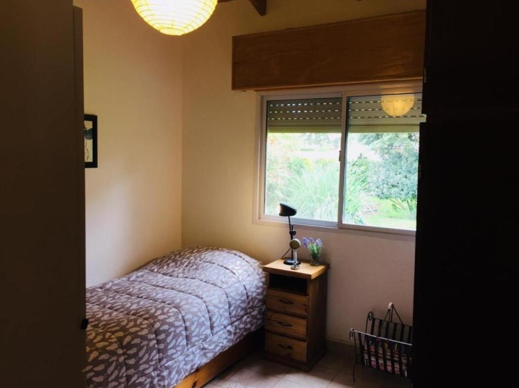 a bedroom with a bed and a window at Casa Magnolia in Sierra de la Ventana