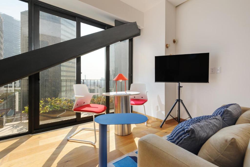 a living room with a couch and a tv at Casa Colon in Mexico City
