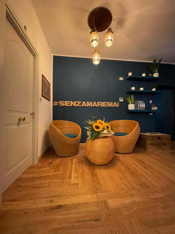 a room with two wooden chairs and a blue wall at Isolotto Guest House in Porto Ercole